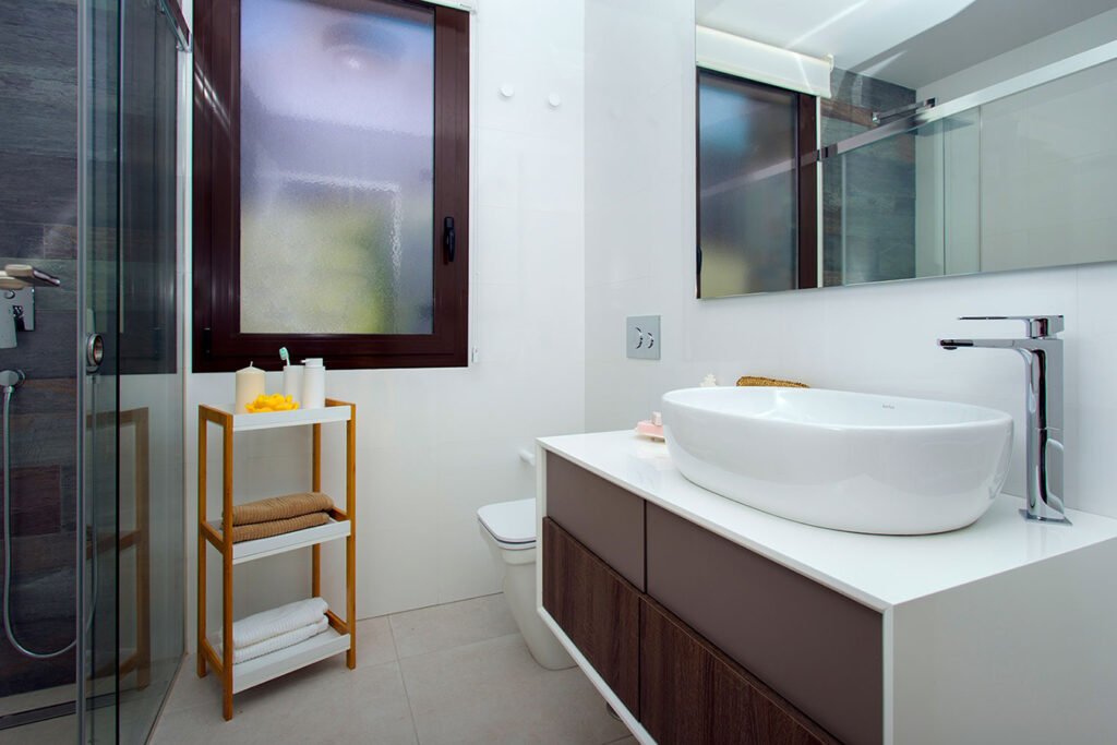 Decoración de un aseo pequeño de diseño minimalista con sanitarios blancos suspendidos, mampara de cristal y tonos claros