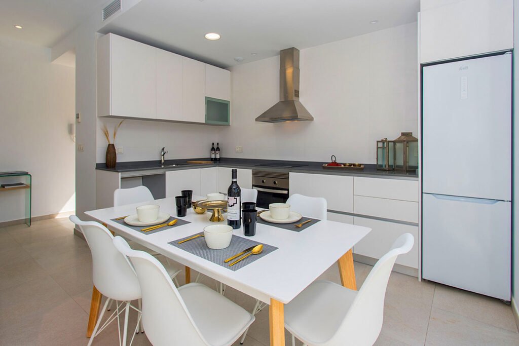 Amplitud y diseño de interiores en una cocina moderna de concepto abierto con falsos techos iluminados con focos empotrados y tonos neutros