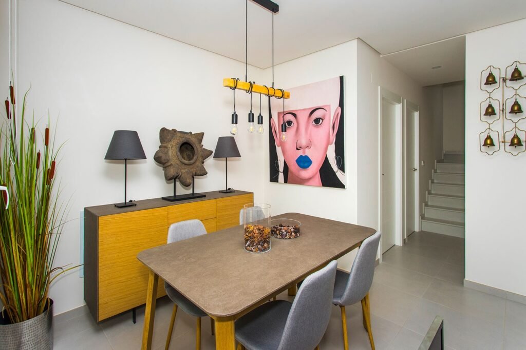 Decoración de salón sofisticado con buffet de madera, retrato artístico en la pared y detalles textiles en color mostaza