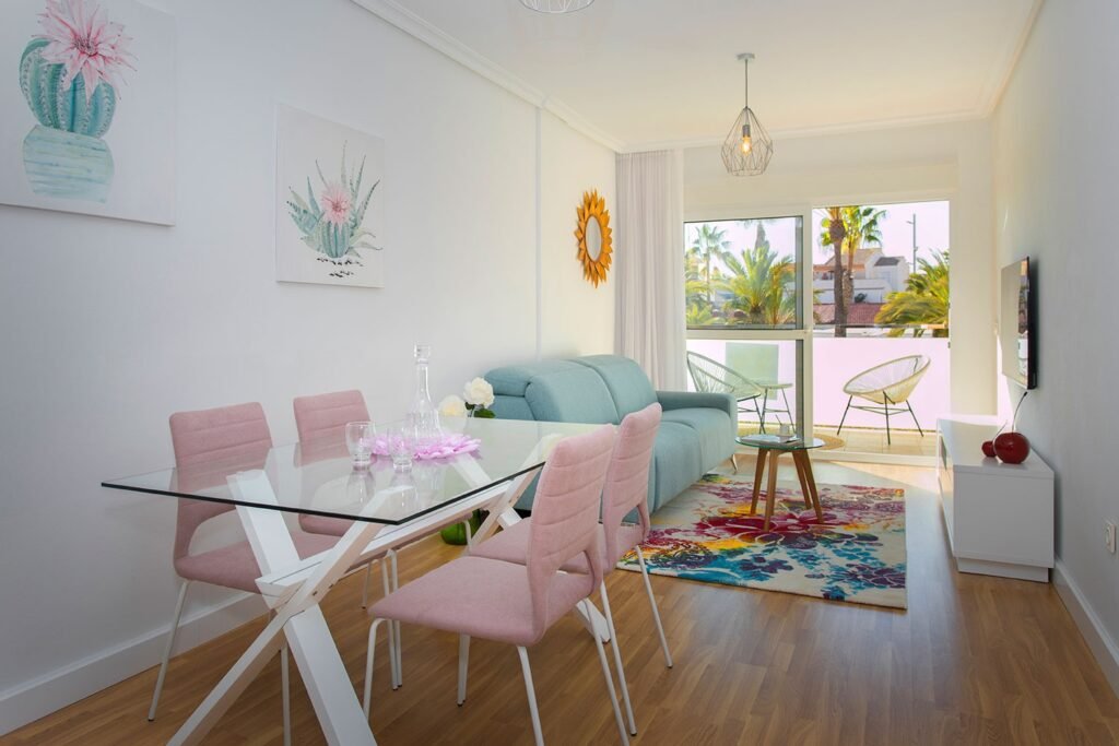Decoración de salón comedor luminoso con cortinas en tonos lila, plantas de interior y ambiente cálido de tarde