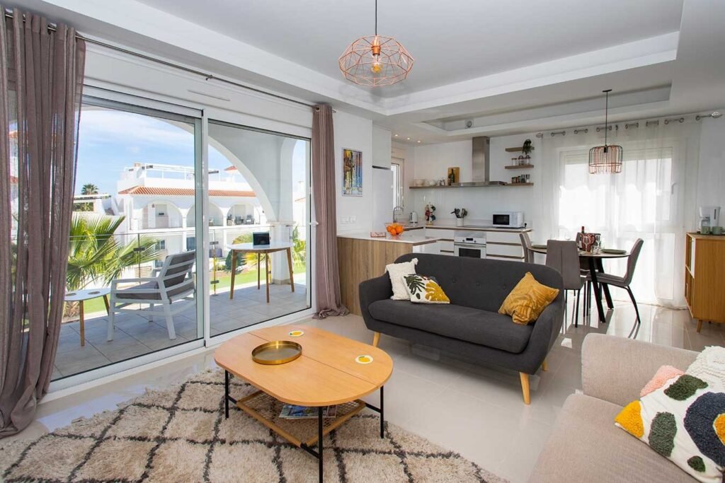 Interior de vivienda de lujo mostrando salón amplio con acceso directo a la terraza y luz natural del atardecer