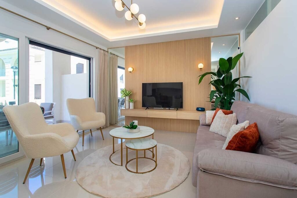 Salón de diseño con pared frontal revestida en listones de madera, iluminación LED indirecta y sofás beige