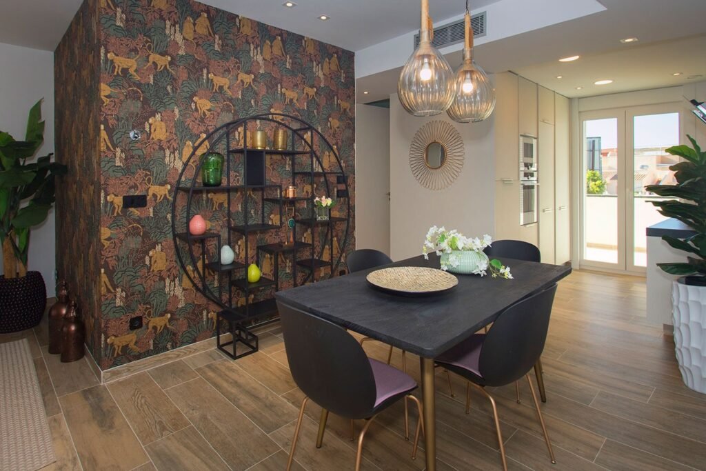 Reportaje fotográfico de un salón de estilo industrial con mesa de comedor oscura, estantería metálica decorativa y pared con revestimiento oscuro elegante