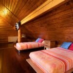 Finca 12 Dormitorio abuhardillado de madera con camas dobles – fotografía inmobiliaria de interiores