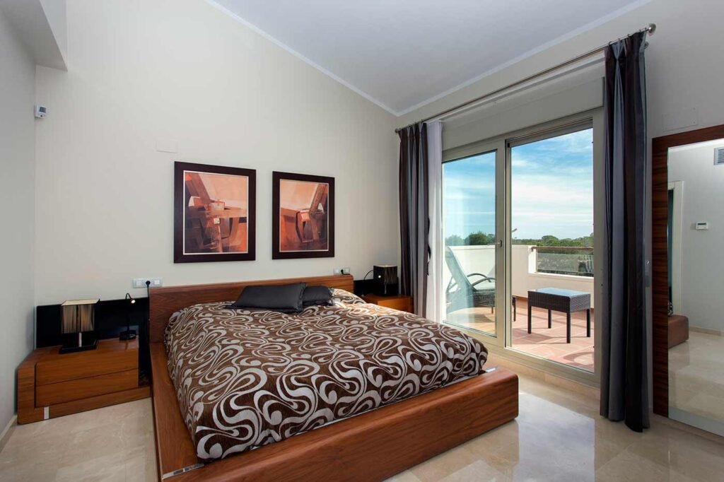 Habitación principal con cama grande, cuadros y acceso directo a terraza exterior