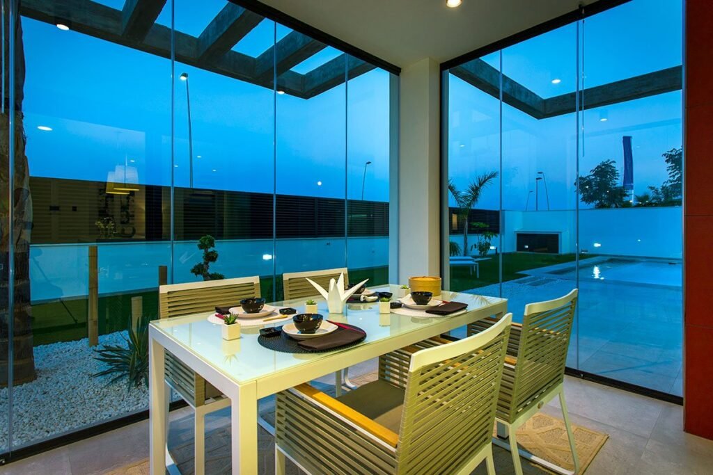 Comedor exterior con acristalamiento en hora azul