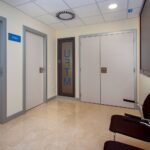 Pasillo de clínica con puertas blancas – fotografía profesional de interiores sanitarios
